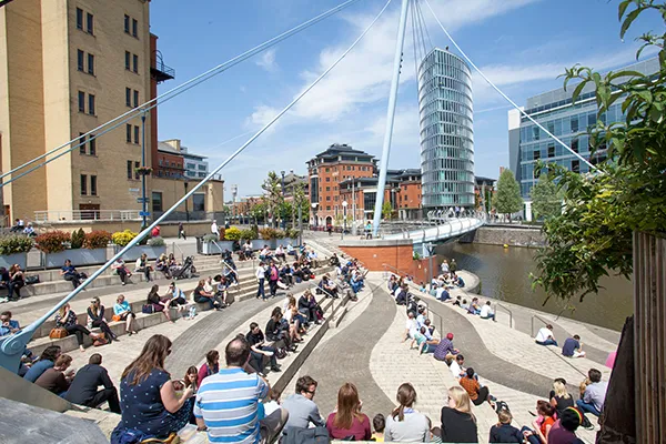 Bristol Temple Quarter steps with people seating in the sunshine having lunch overlooking the river.