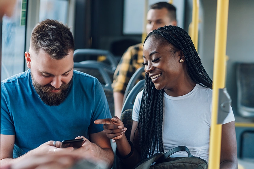 Couple chating and smiling while traveling on bus.